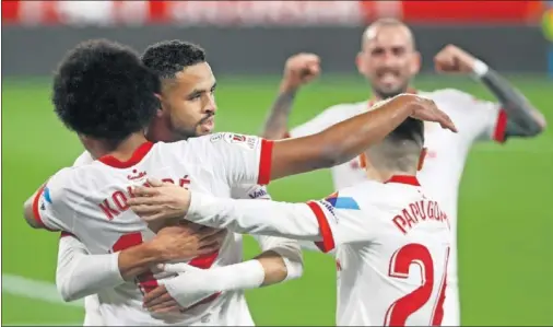  ??  ?? En Nesyri y Papu Gómez abrazan a Koundé después del gol del francés al Barcelona. De fondo, Aleix Vidal también lo celebra.