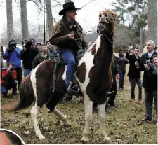  ??  ?? Republican candidate Roy Moore rides away on his horse after voting in Gallant, Alabama. Left: Democratic candidate Doug Jones