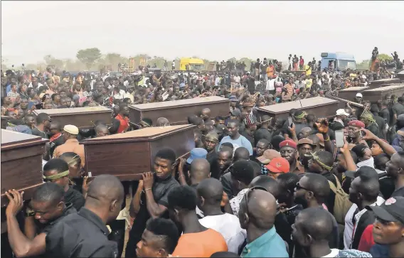  ??  ?? Gruesome deaths: Mourners carry the coffins of the men who were burnt alive in broad daylight through Ibrahim Babangida Square in Benue. The men were burnt to death allegedly because they looked like Fulani herders. Photo: Pius Utomi Ekpei/AFP