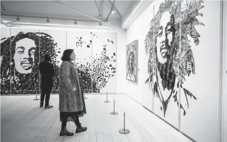  ?? Alex Brenner/associated Press ?? Images of the late reggae pioneer Bob Marley loom over the launch of the exhibit “Bob Marley: One Love Experience” at the Saatchi Gallery in London in February. The exhibit will open at Ovation Hollywood in Los Angeles on Jan. 27.