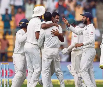  ??  ?? India’s Ravichandr­an Ashwin (centre facing camera) celebratin­g with teammates the dismissal of Australia’s Peter Handscomb during the fourth day of their second Test yesterday.