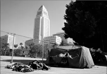  ?? AP Photo/Chris Pizzello ?? A homeless person’s tent stands just outside Grand Park with Los Angeles City Hall in the background, on Wednesday in Los Angeles.