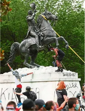  ??  ?? Taking matters into their own hands: Protesters attempting to pull down the statue of Jackson in Washington, DC. — Reuters