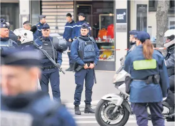  ?? — AFP photo ?? French police officers stand guard at a cordoned off area in front of the financial crimes court building following a bomb alert.