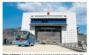  ?? — AFP ?? New gateway: A tour bus driving past the border between China and North Korea as it makes its way to North Korea.