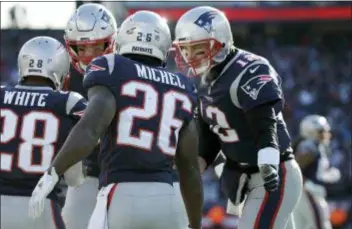  ?? ELISE AMENDOLA — THE ASSOCIATED PRESS ?? Patriots quarterbac­k Tom Brady, right, celebrates a touchdown run by running back Sony Michel during the first half of Sunday’s AFC divisional playoff game against the Los Angeles Chargers. The Patriots won, 41-28.