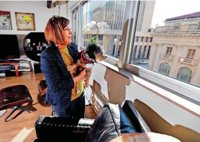  ?? [OKLAHOMAN ARCHIVES PHOTO] ?? Above: Paula Beck and family pet Leo enjoy the view from the living space of the home she shares with husband Don at Carnegie Centre in a February photo. Their loft was part of the Downtown Home Tour in March.