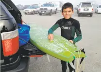  ?? Gino Padua ?? Padua poses with his first surfboard when he was 9 years old. “Even a 5-foot wave freaked me out,” he recalled.