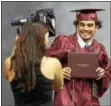  ??  ?? Conestoga graduating senior Sam Samir Bouhdary is about to get his official photo taken after receiving his diploma at Conestoga’s 108th commenceme­nt held at Villanova University.