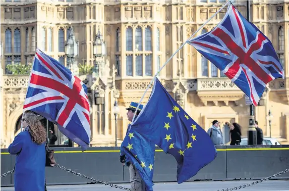  ?? Jack Taylor ?? > Anti-brexit protesters wave Union Jack and EU flags outside the Houses of Parliament last week as Prime Minister Theresa May struck a deal with the EU to move Brexit onto the next phase