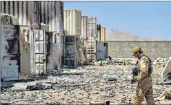  ?? AFP ?? A member of the Taliban Badri 313 military unit walks amid debris, in Kabul on Monday.