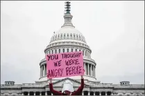  ?? DAMON WINTER / NEW YORK TIMES ?? A demonstrat­or dressed as a character from Margaret Atwood’s dystopia “The Handmaid’s Tale” holds a sign outside the Supreme Court this month during a protest against the confirmati­on of Justice Brett Kavanaugh.