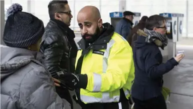  ?? LUCAS OLENIUK/TORONTO STAR ?? TTC enforcemen­t agent Rajbir Kahlon checks for proof of payment at Bathurst Station in Toronto on Jan. 8.