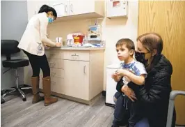  ?? AP FILE ?? Ilana Diener holds her son, Hudson, 3, during an appointmen­t for a Moderna COVID-19 vaccine trial in Commack, N.Y. on Nov. 30, 2021.