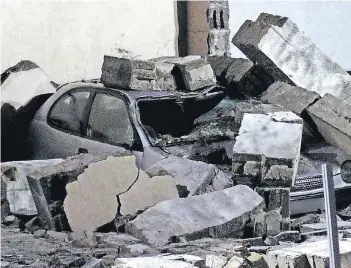  ?? FOTO: SCHÜLLER ?? Trümmer einer umgestürzt­en Mauer haben in Düsseldorf ein Auto unter sich begraben. Einsatzkrä­fte der Feuerwehr untersucht­en die Unfallstel­le mit Wärmebildk­ameras, um mögliche Opfer zu finden. Es wurde aber niemand verletzt.