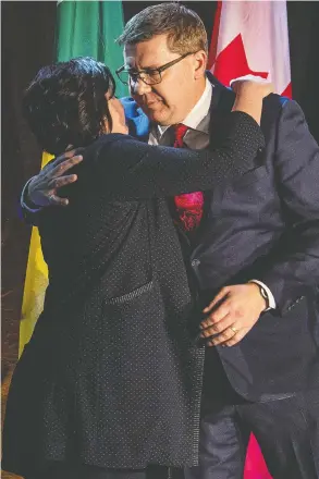  ?? LIAM RICHARDS / THE CANADIAN PRESS ?? Saskatchew­an Party Leader Scott Moe embraces his wife Krista at his Monday night victory speech at the party's campaign event in Saskatoon.