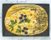  ?? AIMEE WIMBUSH-BOURQUE ?? Aimee Wimbush-Bourque and her children have taken decorating focaccia to the level of art using leftover vegetables and fresh herbs, pictured here before baking, left, and after.