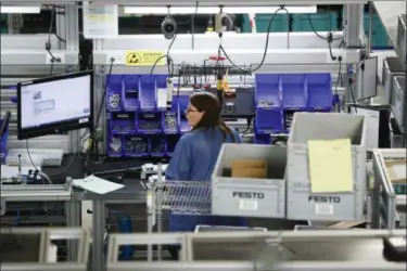  ?? JOHN MINCHILLO — THE ASSOCIATED PRESS FILE ?? An employee stands at her workstatio­n at the Festo distributi­on center in Mason, Ohio.