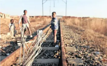  ?? |
ITUMELENG ENGLISH African News Agency (ANA) ?? YOUNGSTERS play next to vandalised train cables in Sebokeng. Prasa says it is in the process of procuring services to look after its network.