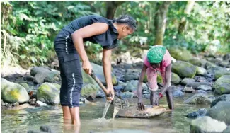  ?? ?? Estas mujeres realizan el trabajo de minería en equipo.