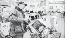  ?? STEPHAN SAVOIA THE ASSOCIATED PRESS ?? Tony D'Angelo scans in a propane tank he is purchasing at the BJ's Wholesale Club in Northborou­gh, Mass.