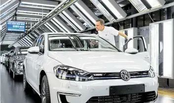  ?? DPA-BILD: SKOLIMOWSK­A ?? Volkswagen-Mitarbeite­r Sven Artmann bei der finalen Kontrolle eines VW e-Golf im Lichttunne­l in der Gläsernen VW-Manufaktur Dresden.