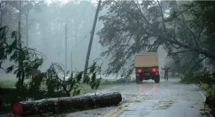  ??  ?? Seorang petugas penyelamat membantu lori yang hampir dihempap pokok susulan ribut kuat di New Bern, Carolina Utara, kelmarin.