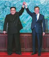  ?? Bloomberg ?? Kim Jong-un and Moon Jae-in raise their hands after signing a deal to end a sevendecad­e war during the inter-Korean summit at the Peace House in the village of Panmunjom, yesterday.