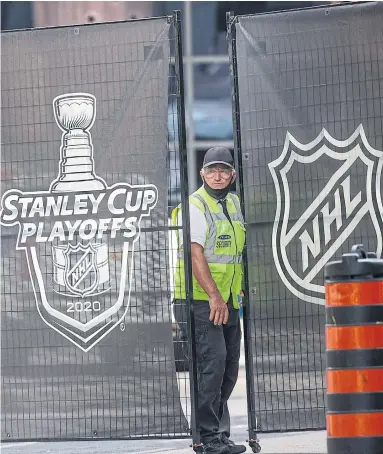  ?? RICK MADONIK TORONTO STAR ?? A security guard stands at his post where personnel enter and exit the NHL bubble in front of Scotiabank Arena.