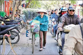  ?? (AP) ?? In this file photo, a flower vendor wheels her bicycle though traffic in Hanoi’s Old Quarter, Vietnam. The country’s economy grew by 7.31 percent in the third quarter year-on-year, the General Statistics Office (GSO) said on Saturday.