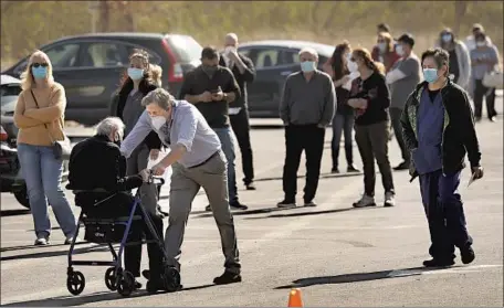  ?? Al Seib Los Angeles Times ?? A MAN receives assistance as people wait for COVID- 19 vaccinatio­ns at the Hansen Dam Recreation Center in the San Fernando Valley.