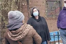  ?? EMILY LESHNER/AP ?? Sofia Moncayo, center, leads a food distributi­on program through Mosaic West Queens Church in the Sunnyside section of the Queens borough of New York.