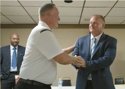  ?? ANDY LAVALLEY/POST-TRIBUNE ?? Former Crown Point Mayor David Uran, left, congratula­tes Pete Land shortly after Land won a caucus to replace him on Thursday in Crown Point.