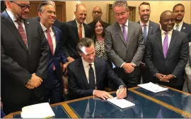  ?? ADAM BEAM — THE ASSOCIATED PRESS ?? Gov. Newsom signs a law overhaulin­g charter schools on Thursday in Sacramento. The law gives districts authority in deciding what charter schools are allowed within their boundaries.