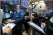  ?? RICHARD DREW — THE ASSOCIATED PRESS ?? Specialist Patrick King, left, works with traders at his post Tuesday on the floor of the New York Stock Exchange.