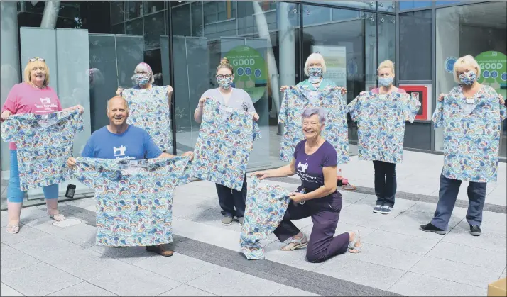  ??  ?? RAINBOW SCRUBS Lin Gell, Malcolm Dent and Julie Greenwood from Team Scrubbers donating to neonatal staff at Queen Alexandra Hospital