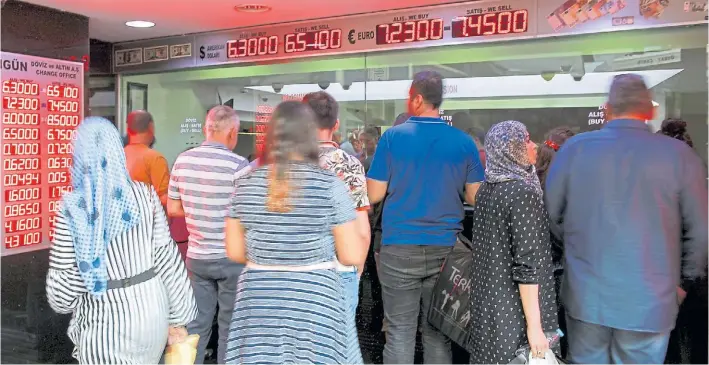  ?? AP ?? En la fila. Un grupo de ciudadanos turcos en una casa de cambio en Estambul. El presidente llamó a vender dólares y euros, pero pocos le hicieron caso y salieron a comprar.