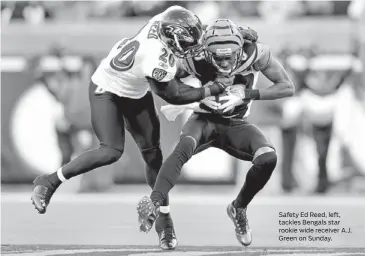  ?? ANDY LYONS/GETTY PHOTO ?? Safety Ed Reed, left, tackles Bengals star rookie wide receiver A.J. Green on Sunday.