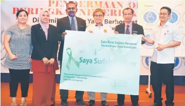  ??  ?? Dr Annuar (third right), Dr Kamarudin (second right) and Dr Davis (third left) showing the signed pledge card as others look on.