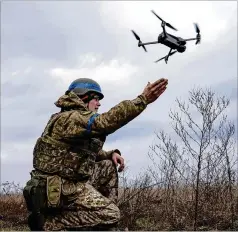  ?? EVGENIY MALOLETKA/AP ?? A Ukrainian serviceman of the 68 Oleksadovb­ush hunting brigade launches a drone at the front line near Vuhledar last week. Drones launched from Ukraine now seem to be targeting more areas.