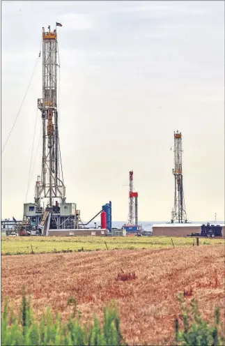  ??  ?? Three rigs drill wells in the STACK play last summer. Continenta­l Resources announced Wednesday it sold one of its water handling systems in the eastern portion of the play to Lagoon Water Solutions for $85 million. [OKLAHOMAN ARCHIVES]