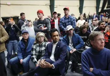  ?? KEVIN DIETSCH — GETTY IMAGES ?? Republican presidenti­al candidate and businessma­n Vivek Ramaswamy, center, listens as former President Donald Trump speaks to voters during a visit to a caucus site at the Horizon Event Center in Des Moines, Iowa, on Monday.