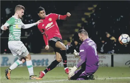  ??  ?? Marcus Rashford fires home Manchester United’s opening goal in last night’s FA Cup fourth round tie at Yeovil Town.
