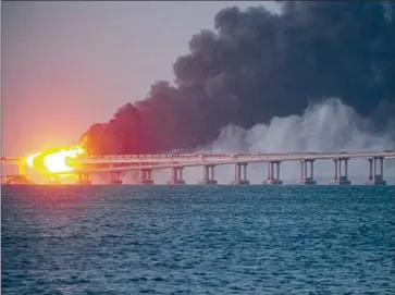  ?? Associated Press ?? PART of the Kerch Bridge, which connects Crimea to the Russian mainland, burns after an attack on Oct. 8.