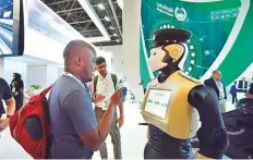  ?? Clint Egbert/Gulf News ?? Delegates interact with a Dubai Police Robot on display at the Gitex Technology Week.