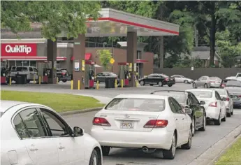  ?? MEGAN VARNER/GETTY IMAGES ?? Cars line up at a QuickTrip gas station on Tuesday in Atlanta.