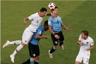  ?? Associated Press ?? ■ Portugal's Adrien Silva, right, looks on as Portugal's Jose Fonte, left, and Uruguay's Nahitan Nandez, second right, go for a header during the round of 16 match between Uruguay and Portugal on Saturday at the 2018 World Cup at the Fisht Stadium in...