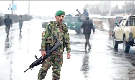  ?? KOHSAR/AFP WAKIL ?? Afghan security personnel stand guard near the site of an attack near the Marshal Fahim Military Academy base in Kabul yesterday.