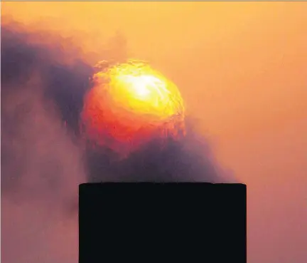  ?? HASAN JAMALI/AP ?? Smoke rises from an oil pipe at sunset in the desert oilfield in Sakhir, Bahrain. OPEC nations have agreed to reduce their production to help boost global oil prices, but to no avail. Crude prices are at a standstill and cuts have been extended by at...