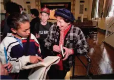  ?? Brant Ward / The Chronicle 2000 ?? Hannah Pick-Goslar (right), with her grandson Benny Meir (center), watches as Brandon Bucscit finds her name in Anne Frank’s diary at Horace Mann school in San Francisco in 2000.